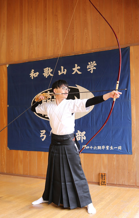 弓道場で弓を引く辻本太一